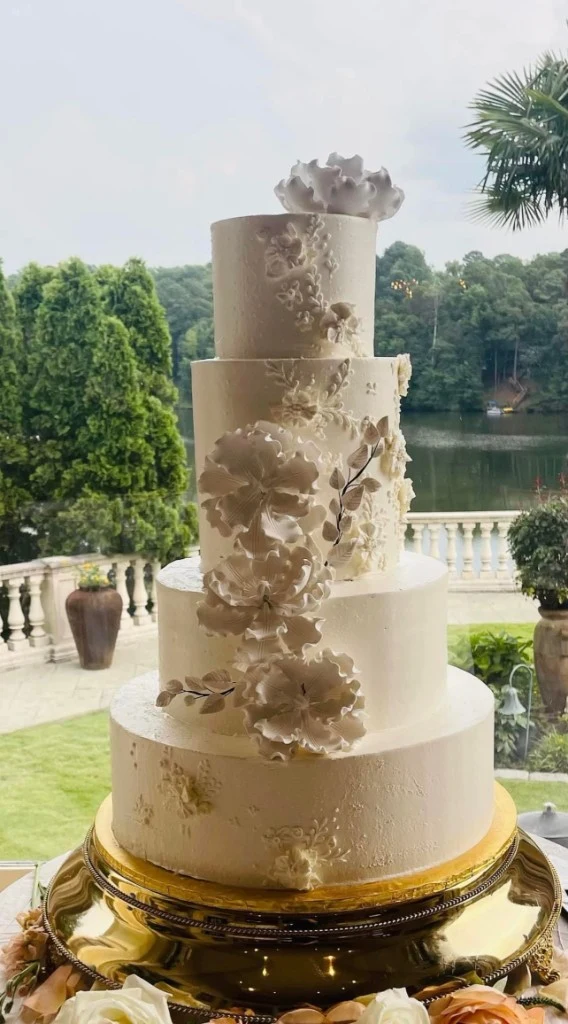 Four-tier white buttercream wedding cake with sculpted sugar flowers by Joe's Bakery